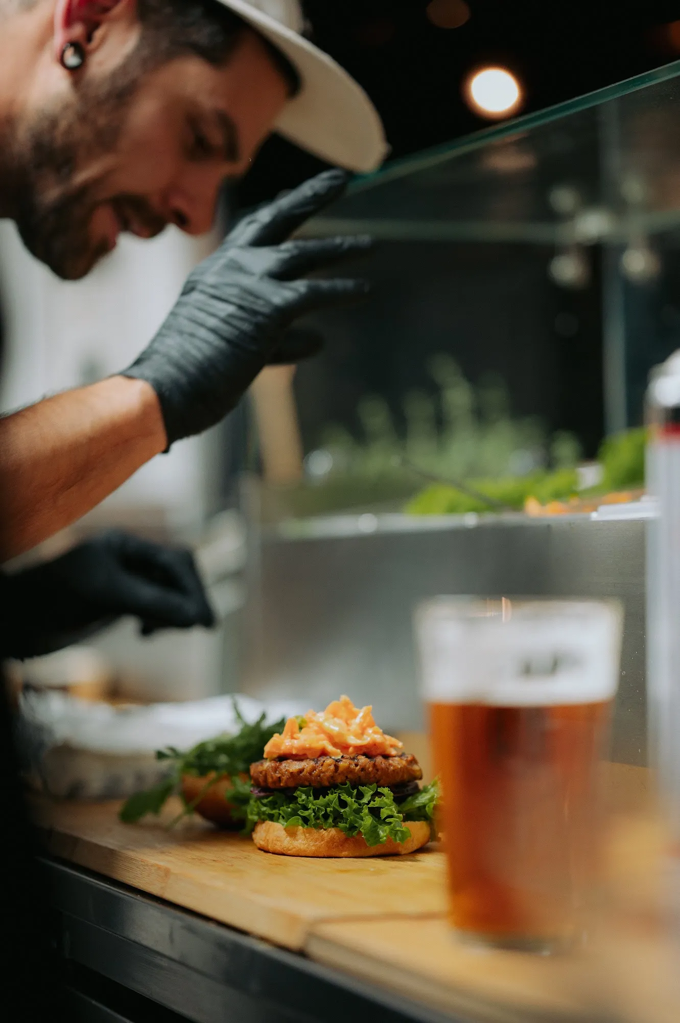 Zubereitung eines Burgers mit schwarzen Handschuhen