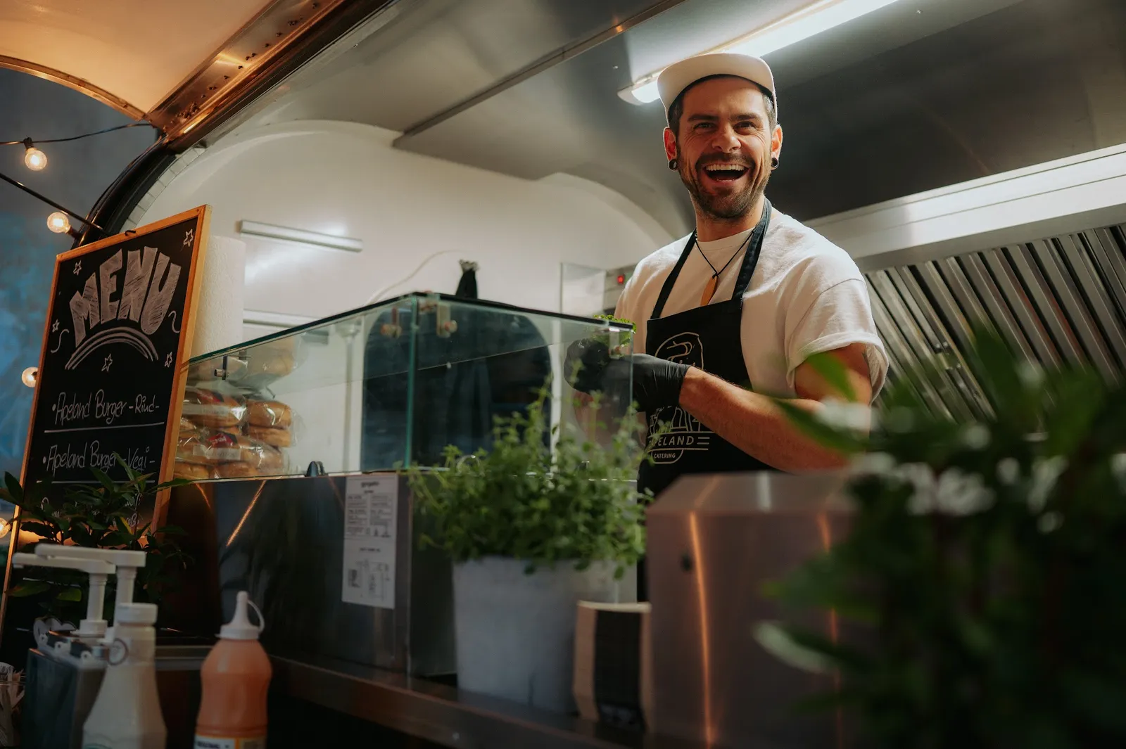 Der Koch im Foodtrailer lächelt in die Kamera